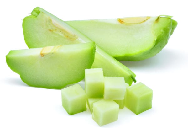 Freshly sliced chayote on a white background