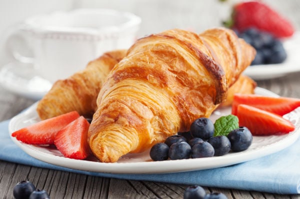 French croissants and fruit on a white plate