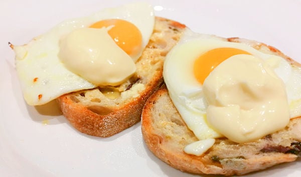 Fried eggs on toast covered in hollandaise