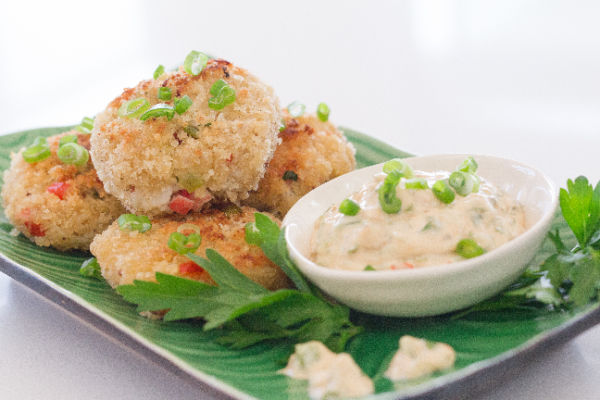 Remoulade next to crab cakes on a platter