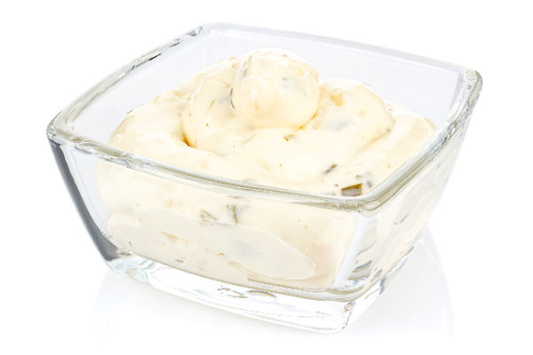 Homemade tartar sauce in a glass dish on a white background