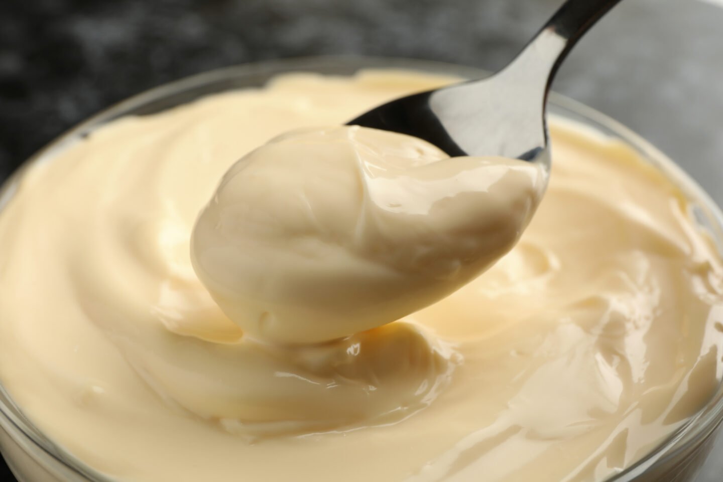 Bowl and spoon with mayonnaise, close up