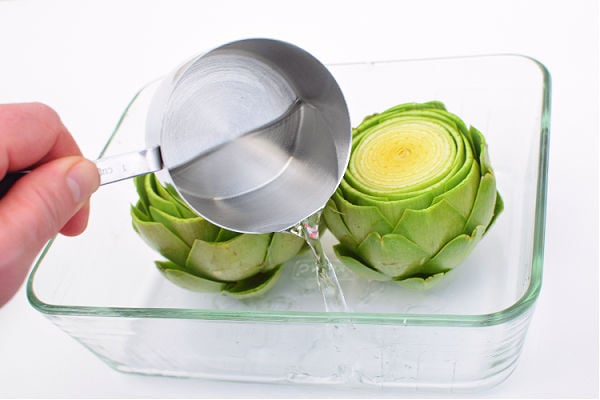 Adding water to artichokes in microwave safe dish
