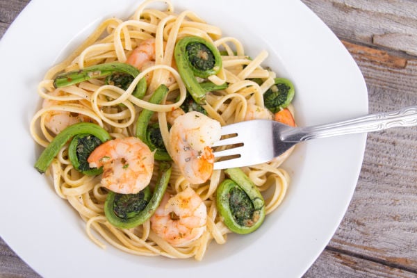 Fiddleheads and pasta in a white plate