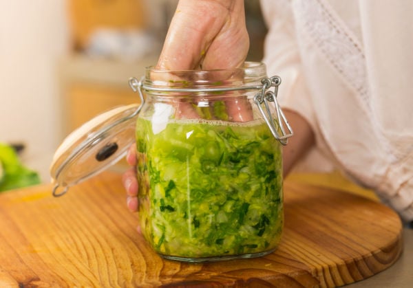 Tamping down the cabbage into a mason jar