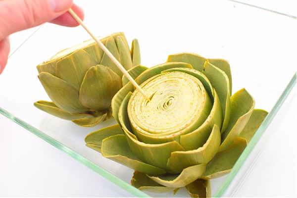 Testing artichokes are cooked with a skewer