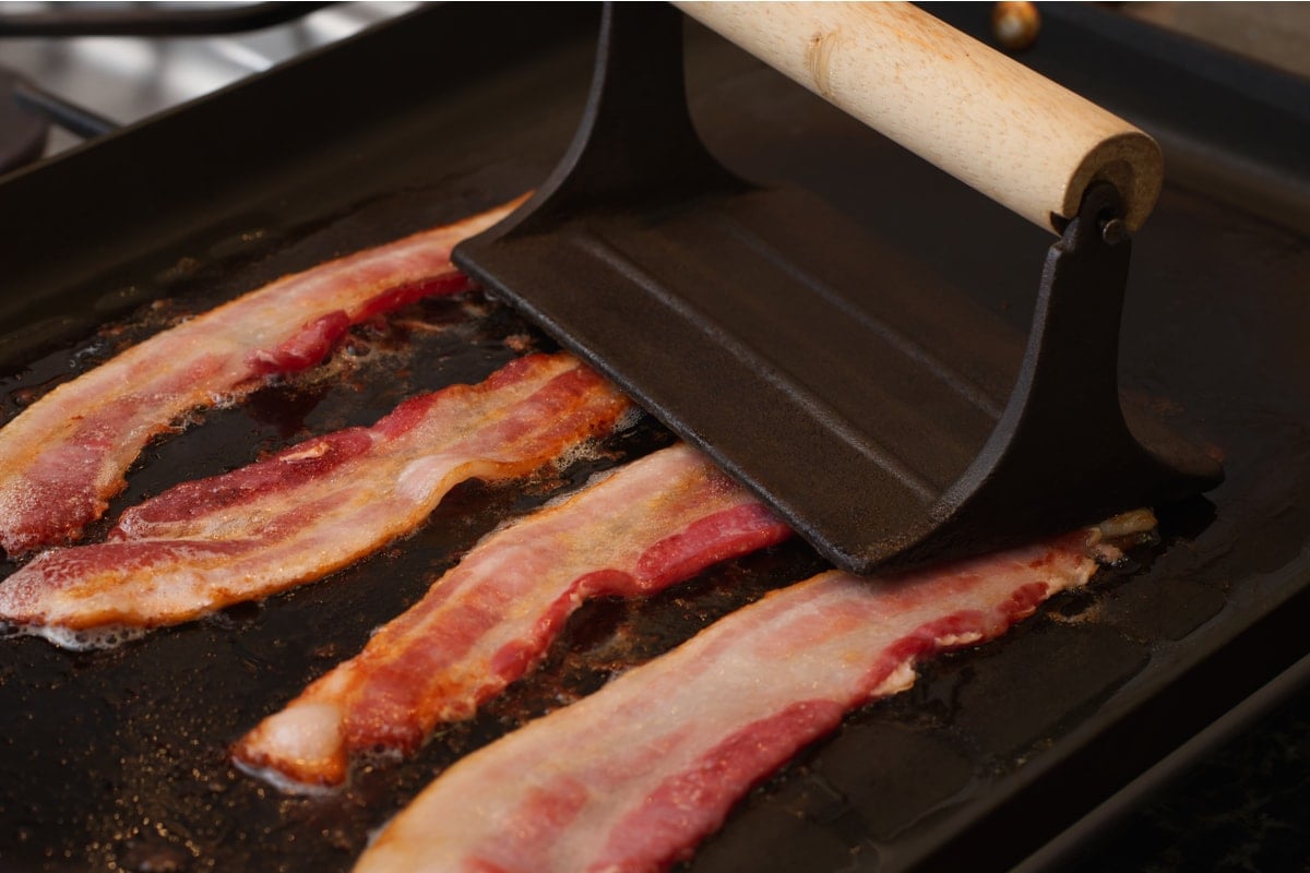 using a bacon press while frying bacon
