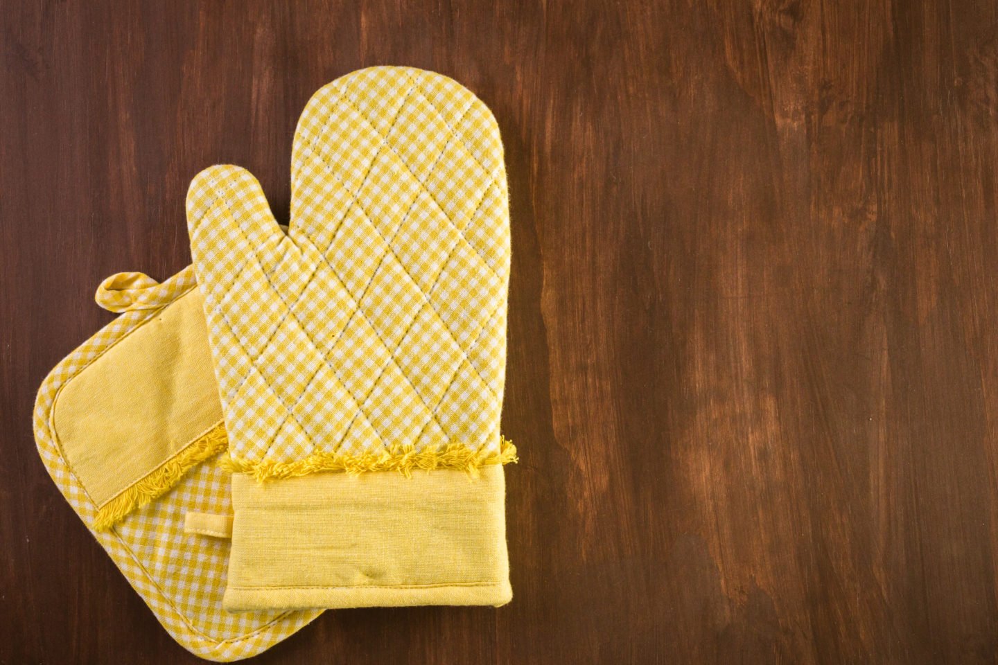 Oven Mitt And Pot Holder On Wooden Background