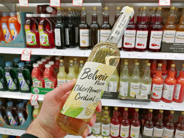 Holding a bottle of Belvoir Farm Elderflower Cordial