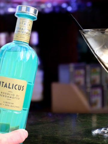 Holding a bottle of Italicus next to a Martini