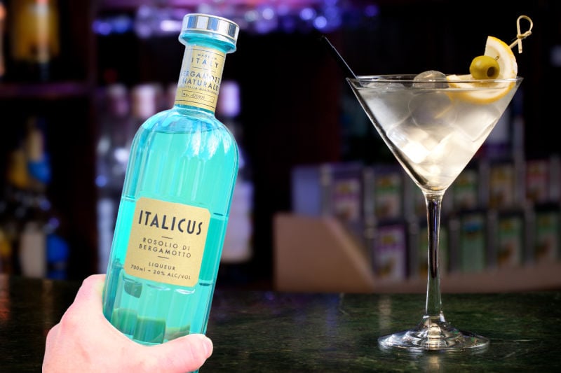 Holding a bottle of Italicus next to a Martini