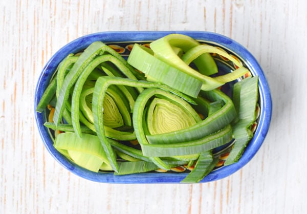 A bowl of raw leek leaves sliced thinly