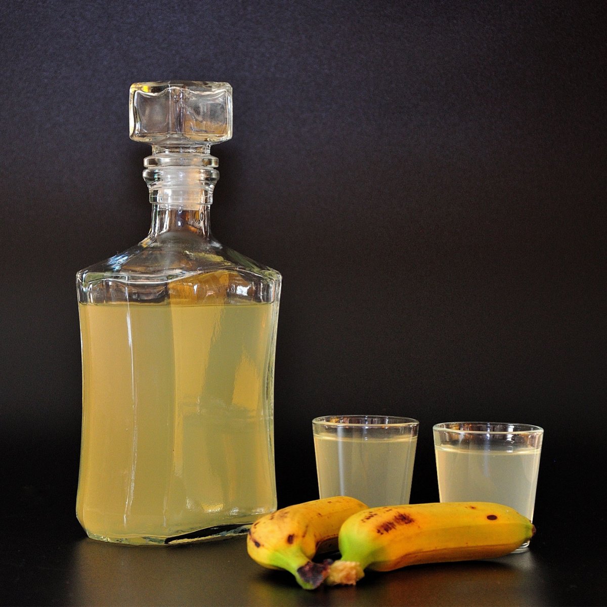 homemade banana liqueur in decanter and two glasses