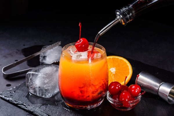 Pouring grenadine into a cocktail