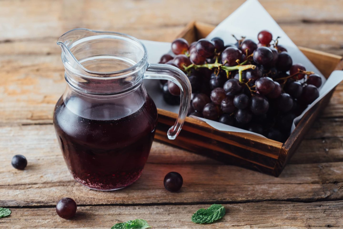 pitcher of grape juice with fresh grapes