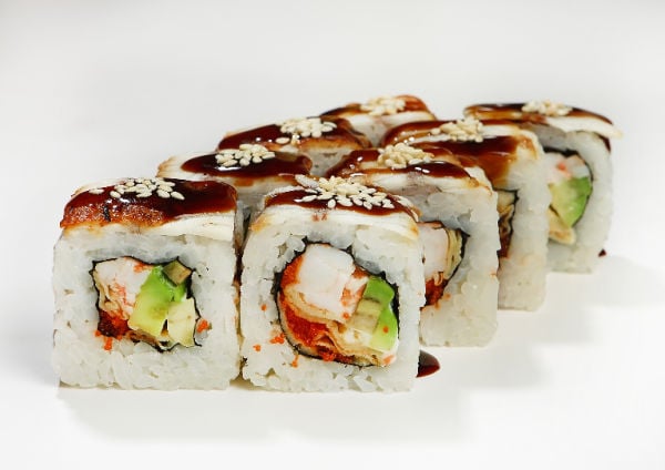 Sushi rolls topped with eel sauce and sesame seeds