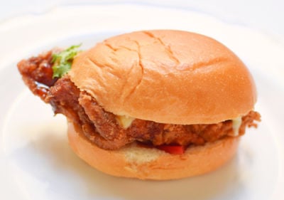 A tempura pork burger on a white plate