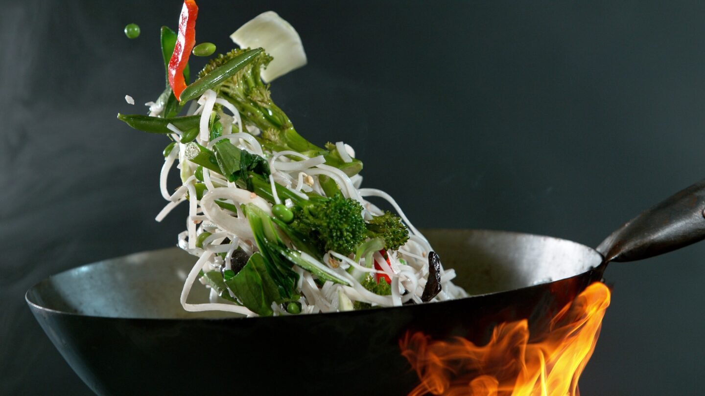 Closeup,Of,Chef,Throwing,Vegetable,Pieces,With,Asian,Noodle,Mix