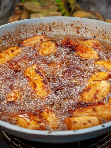 deep frying sugar coated banana plantains in a wok pan