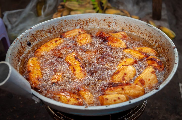 deep frying sugar coated banana plantains in a wok pan