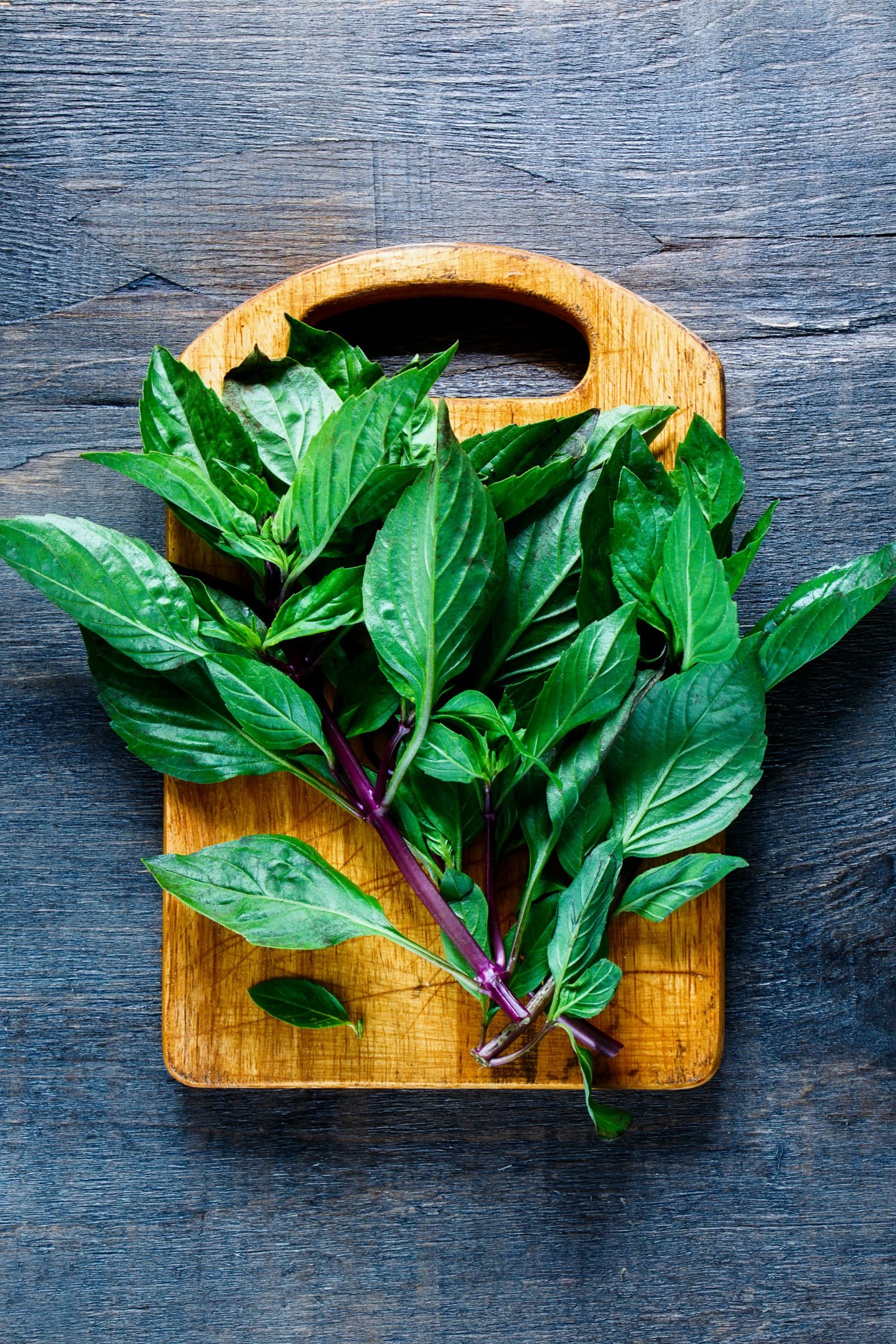 thai basil on wooden chopping board