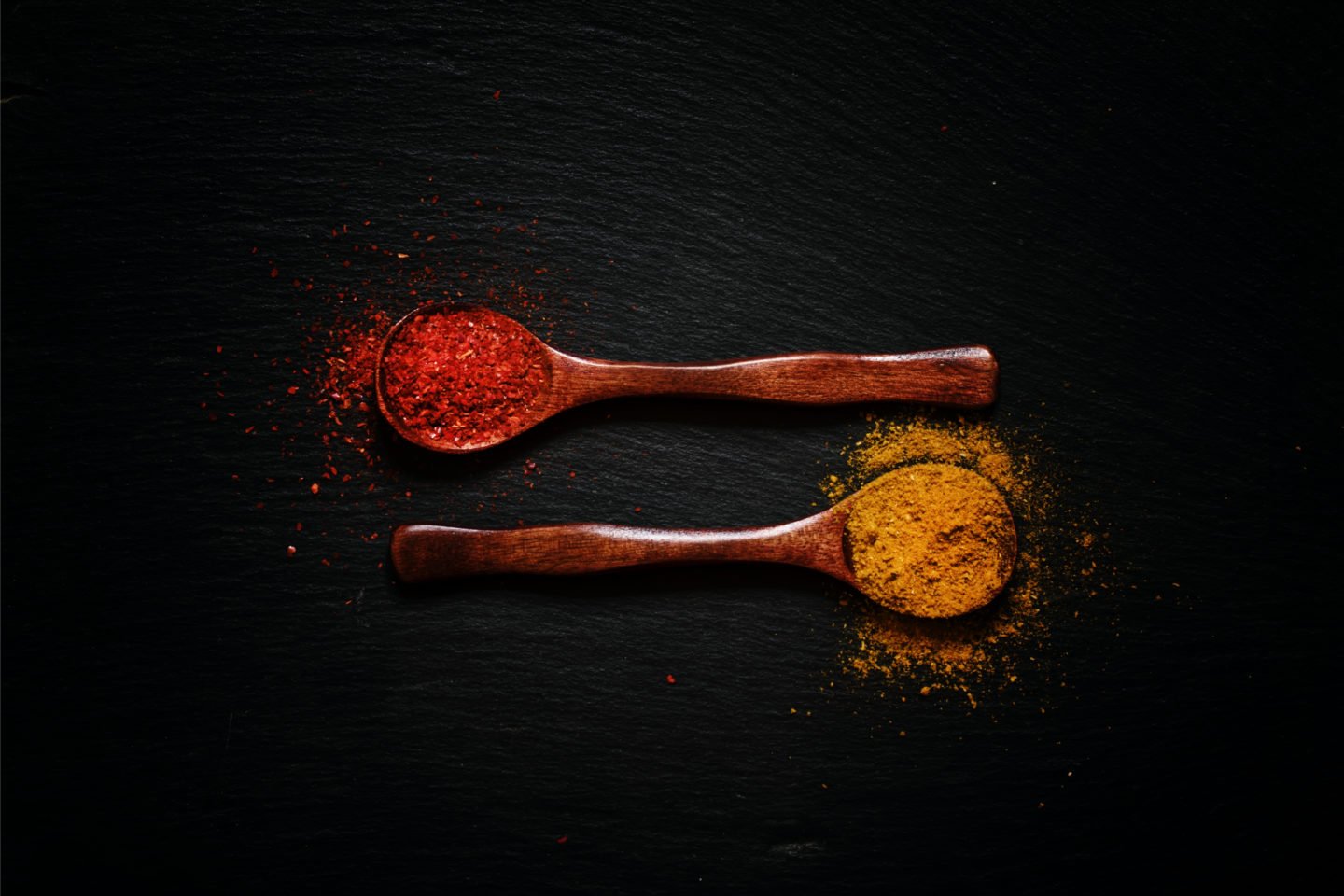 chili powder and cumin in spoons