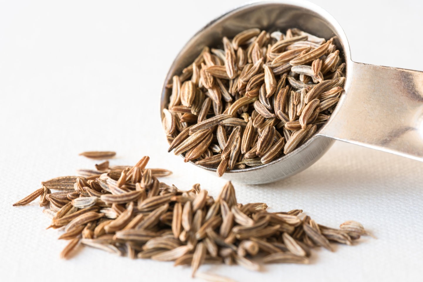 caraway seeds spilled from a spoon