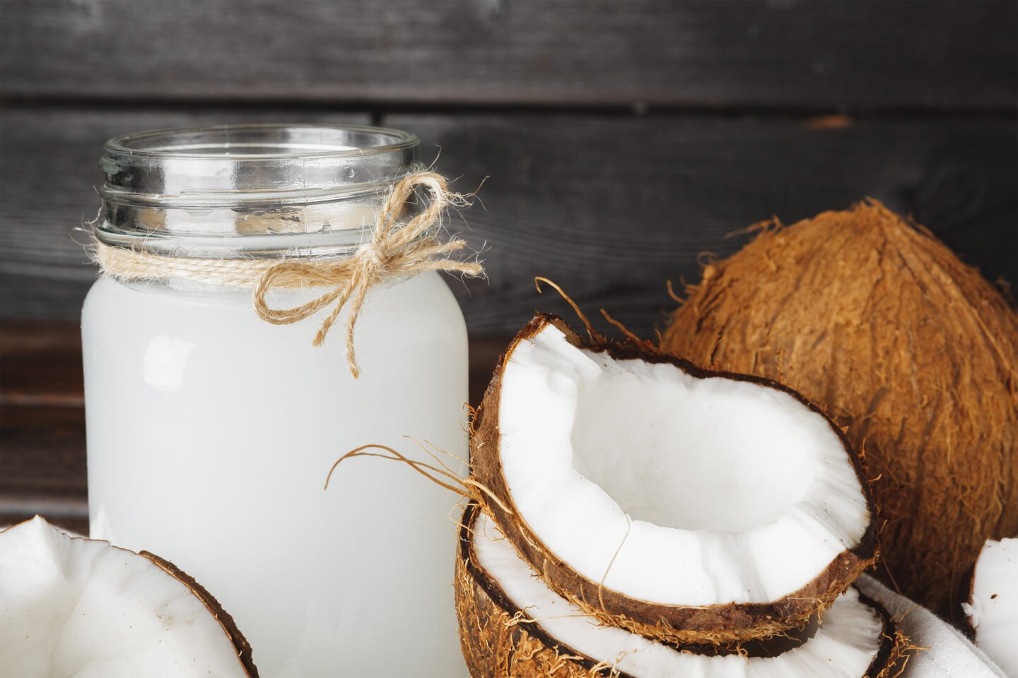 fresh coconuts and a glass jug filled with coconut milk