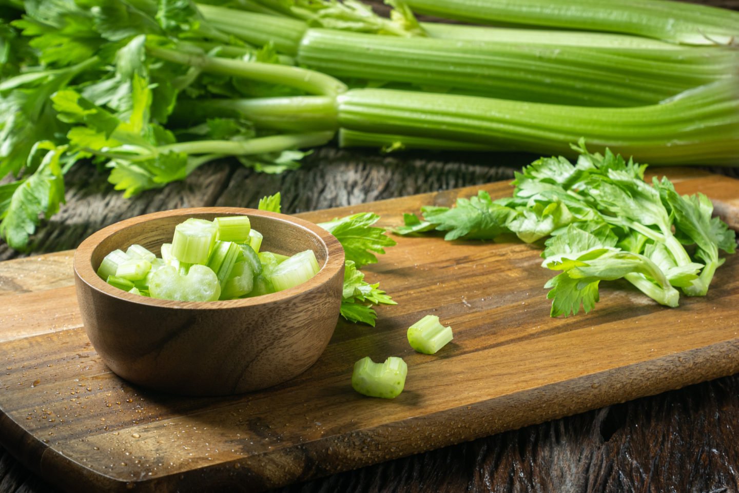 diced celery in a bowl with fresh celery stalks in the background