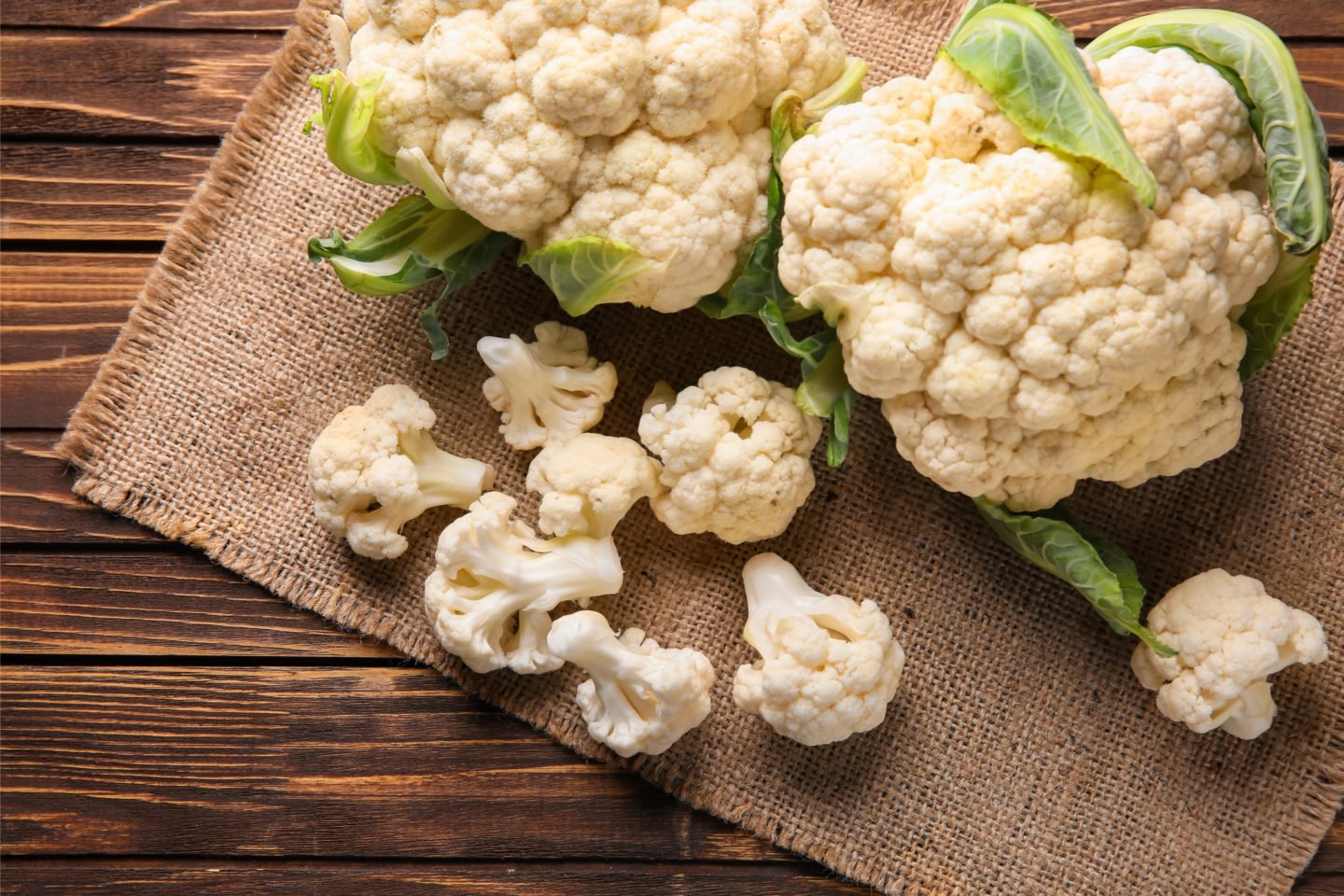 fresh head of cauliflower on wooden table