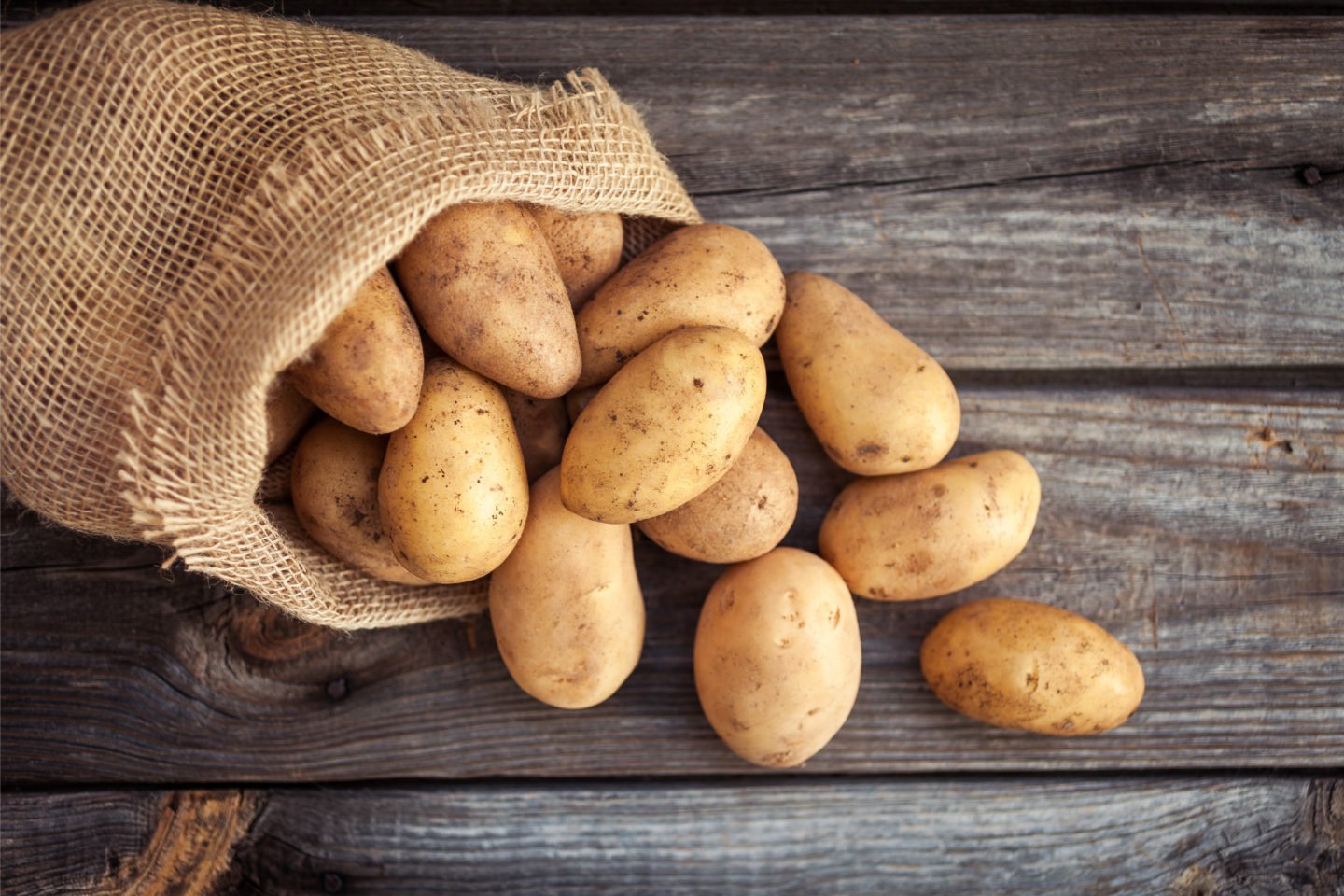 fresh potatoes on wooden table