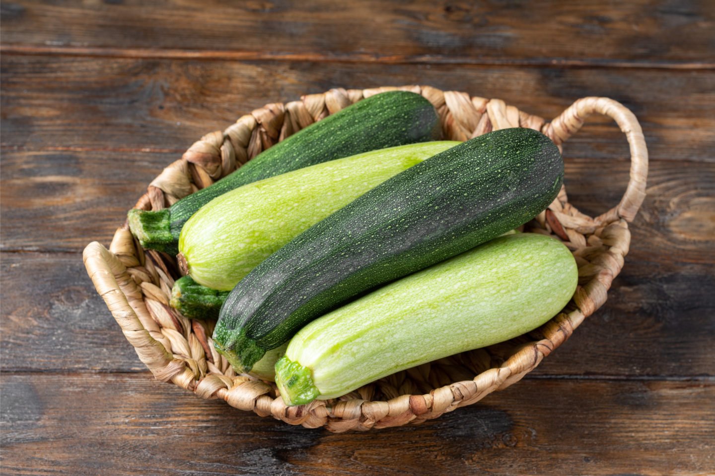 fresh zucchini in wicker basket