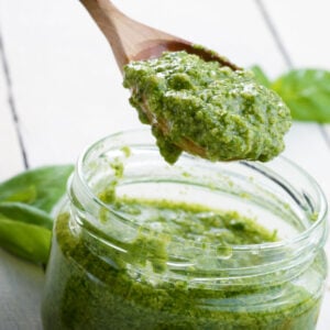 jar of pesto and wooden spoon