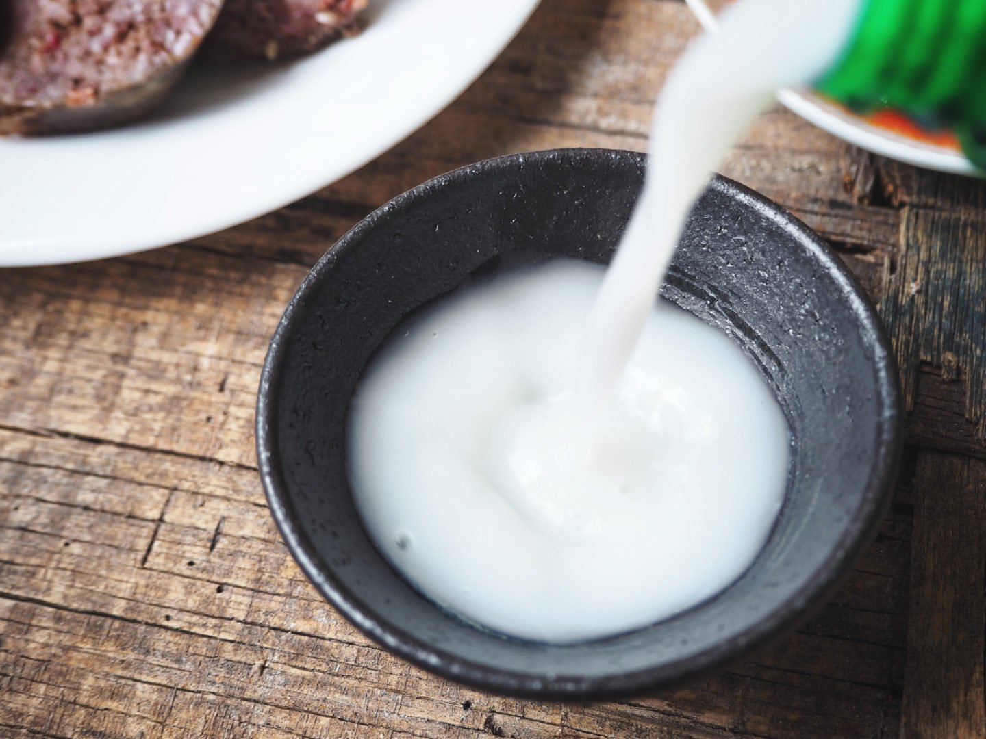 rice wine in small black bowl