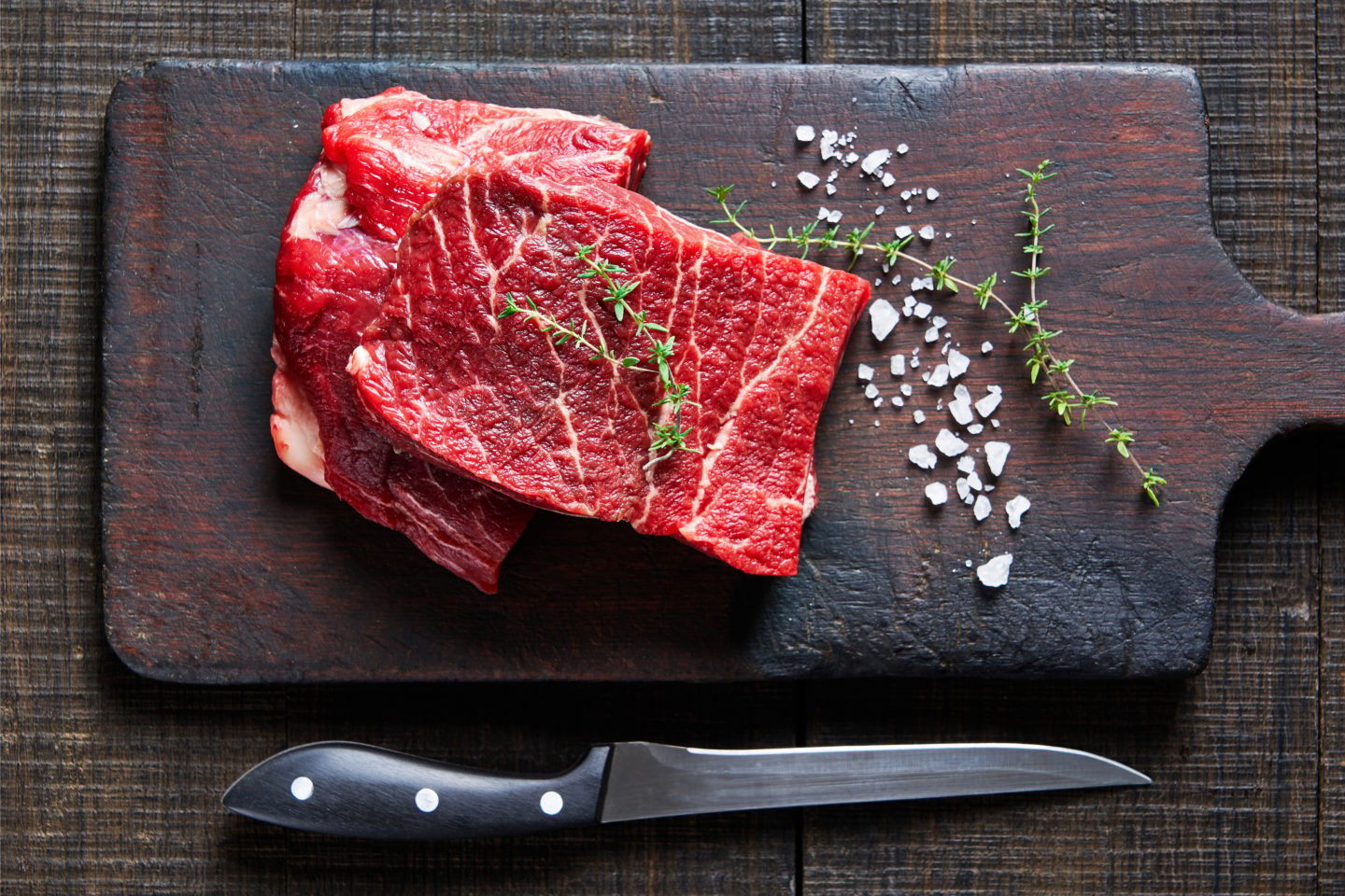 uncooked flat iron steak on cutting board