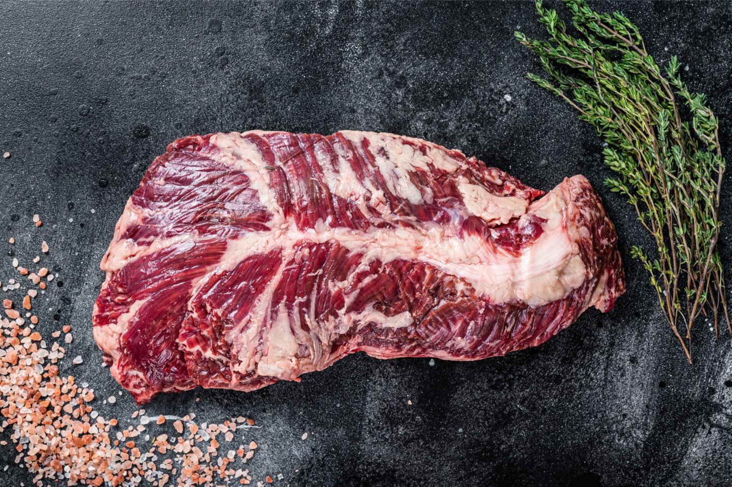 uncooked hanger steak on butcher table