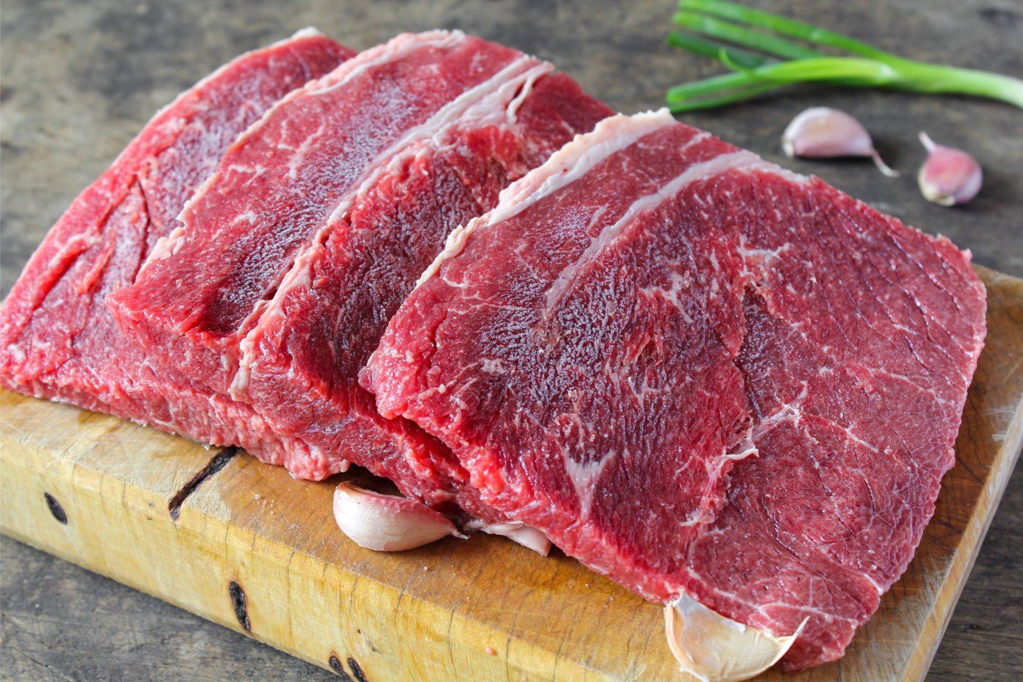 uncooked top round steak on cutting board