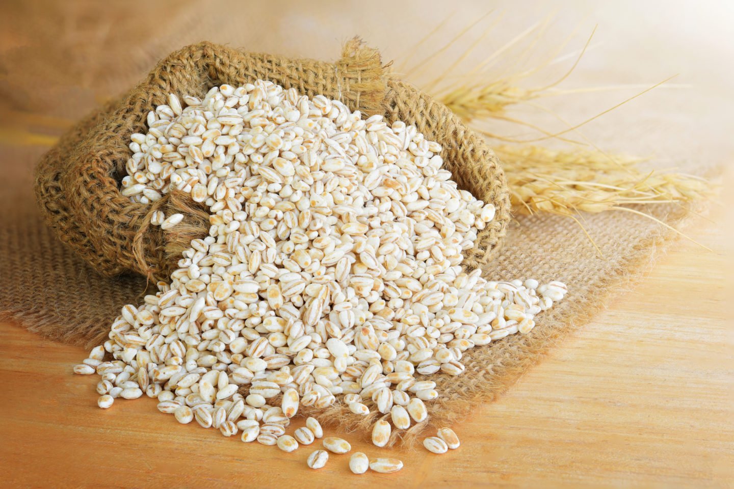 spilled sack of barley on wooden surface