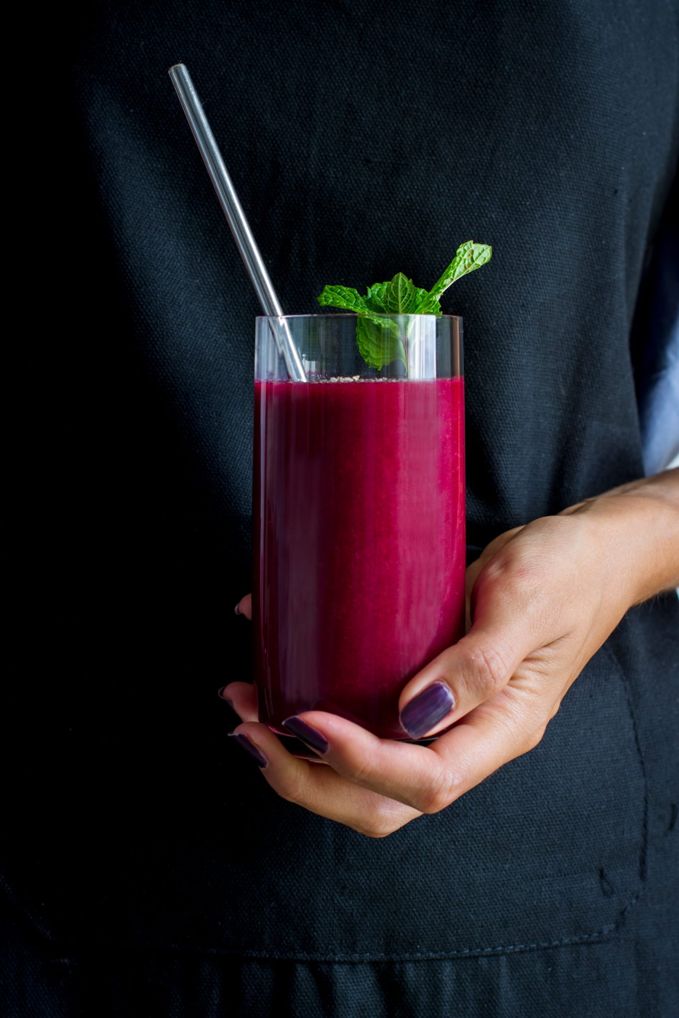 woman holding a glass of beet juice