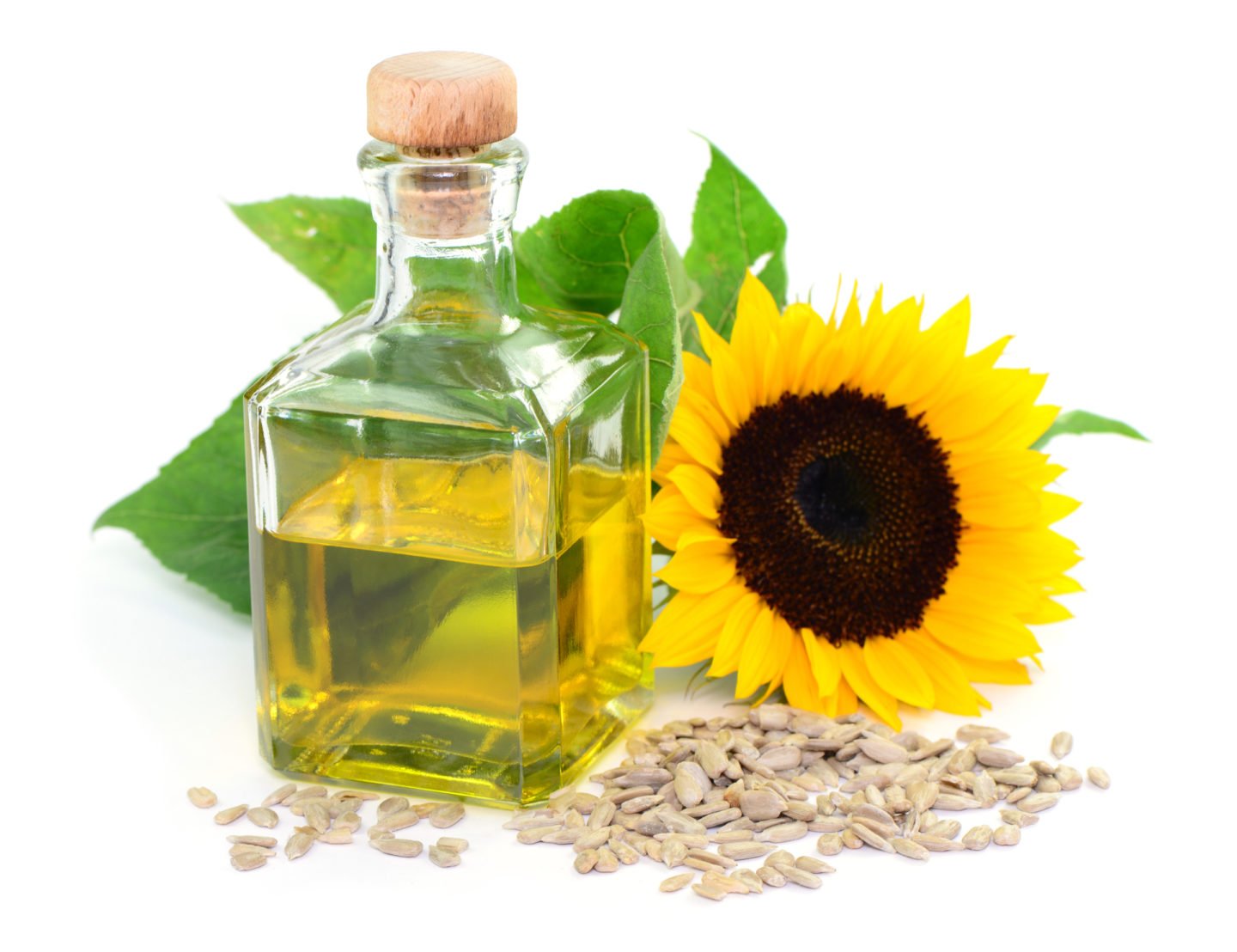 sunflower oil pictured with seeds and flower