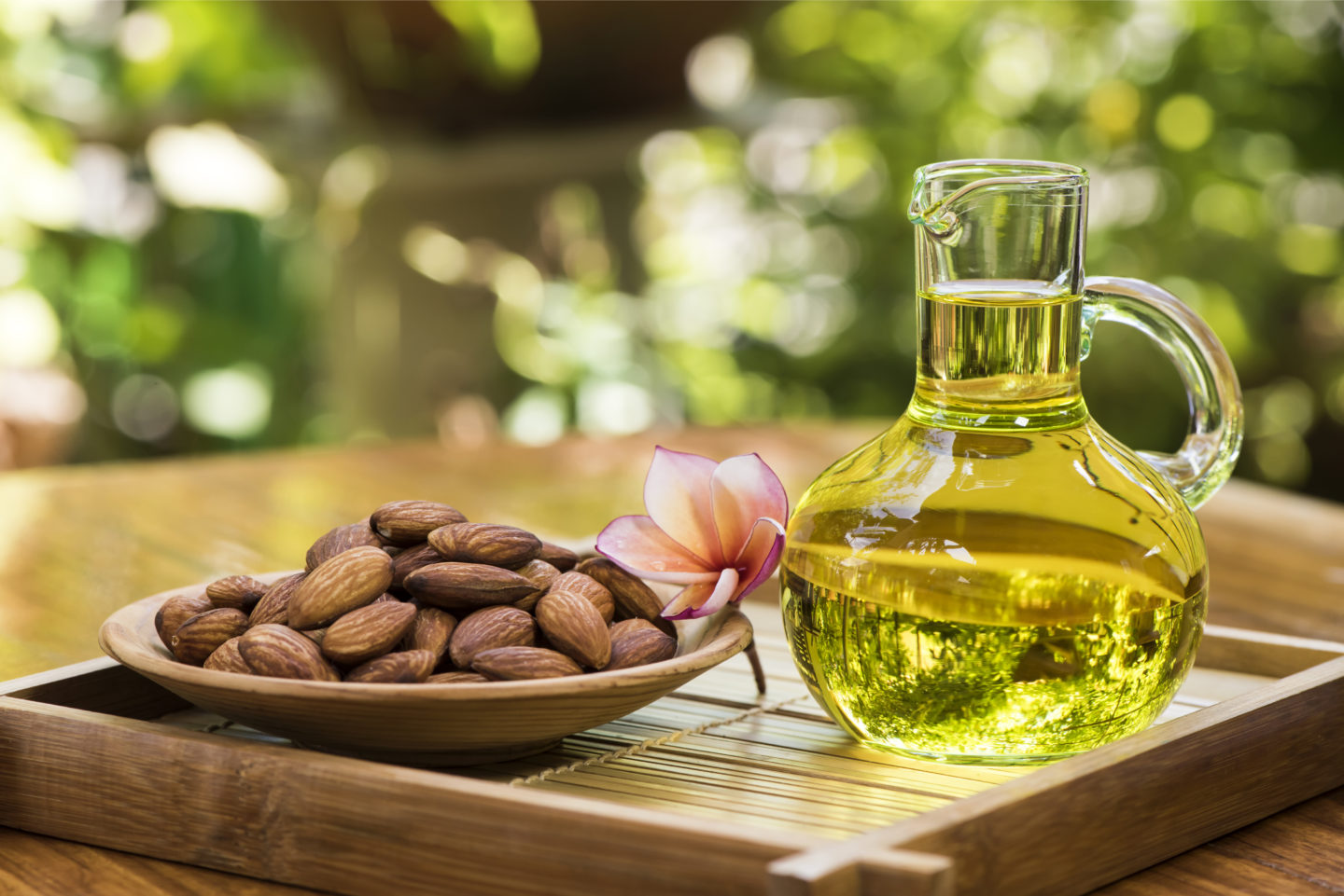 Almond Oil In Glass Jug Beside Plate Of Almonds