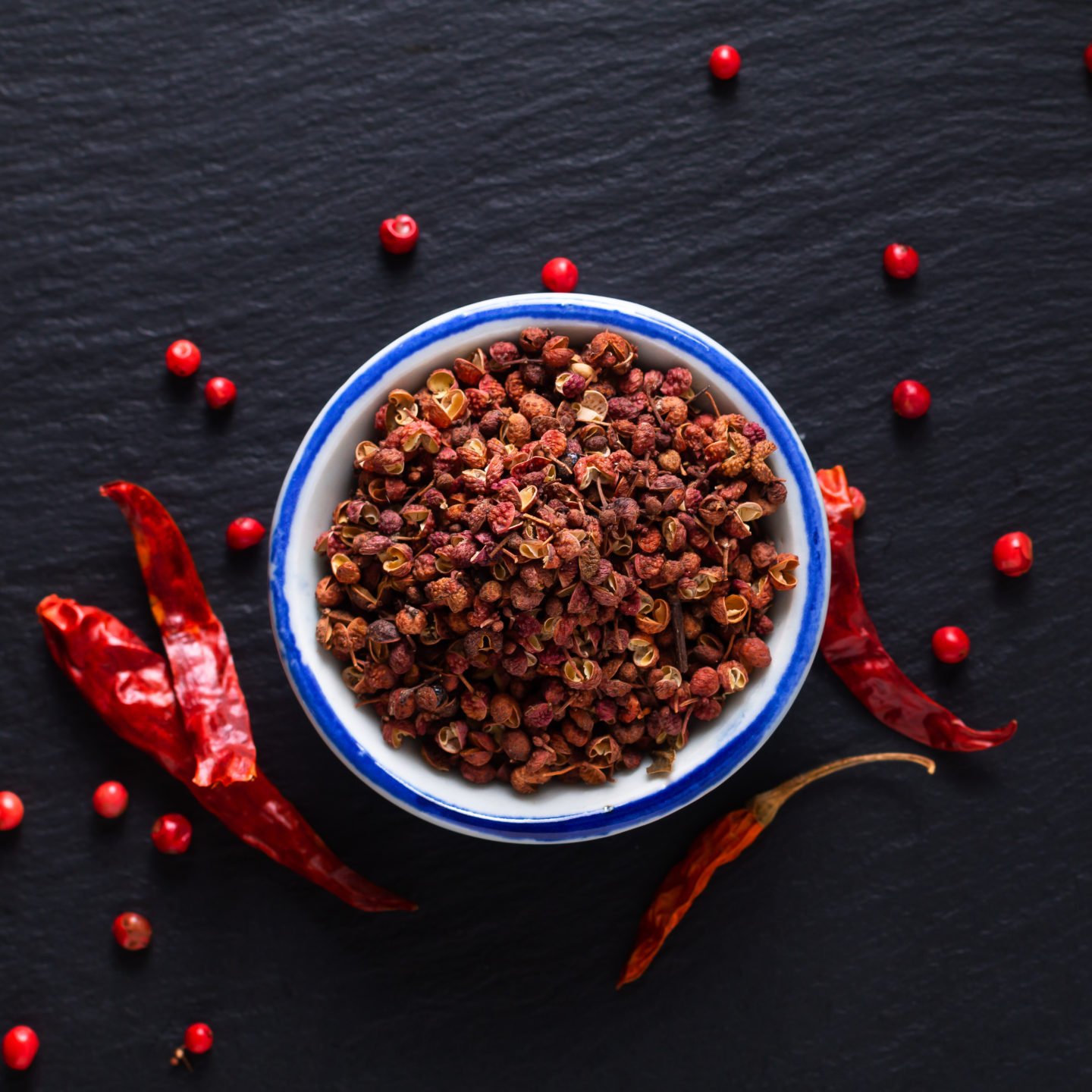 bowl of sichuan peppercorn on wooden surface