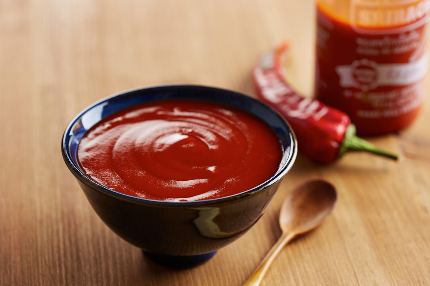 bowl of sriracha on wooden table