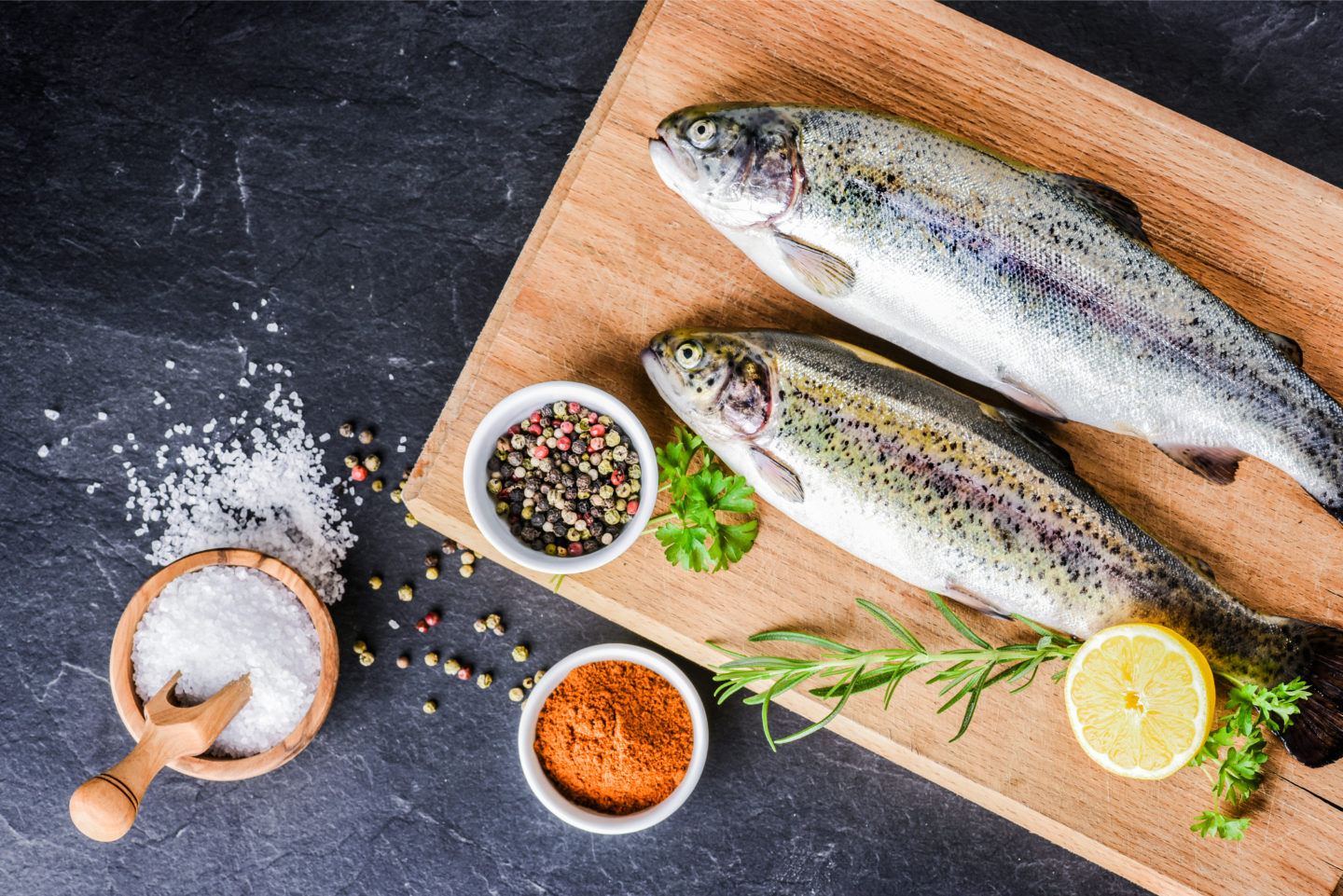 Fresh Rainbow Trouts On Cutting Board With Spices