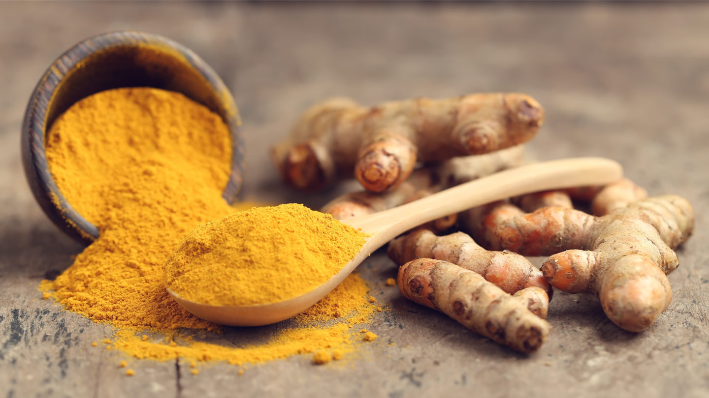 freshly ground turmeric powder on wooden surface