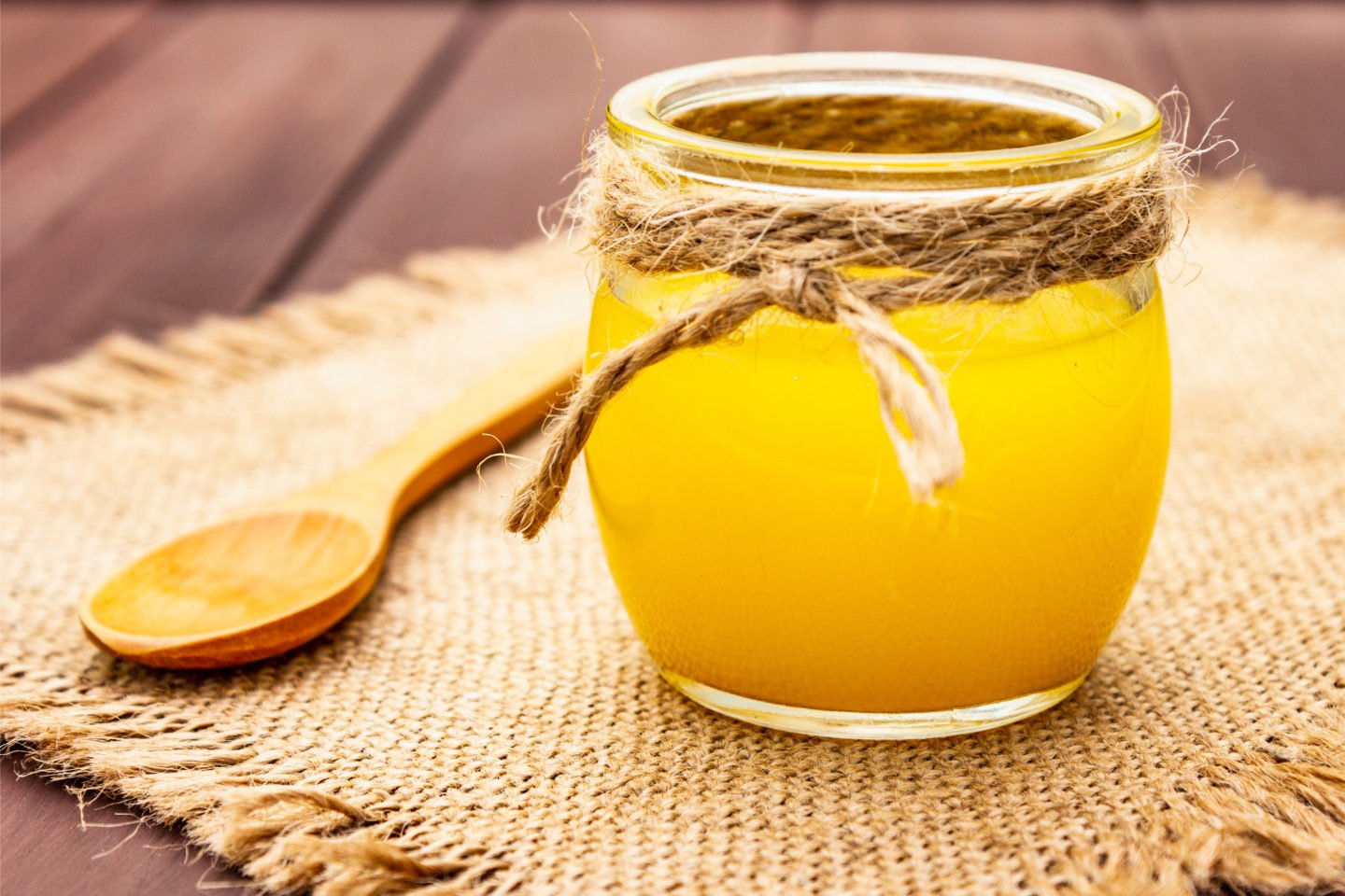Ghee Clarified Butter In Glass Jar With Wooden Spoon
