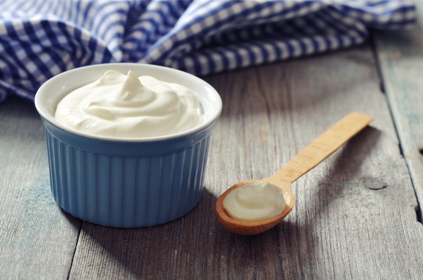 Greek Yogurt In Blue Bowl And Wooden Spoon