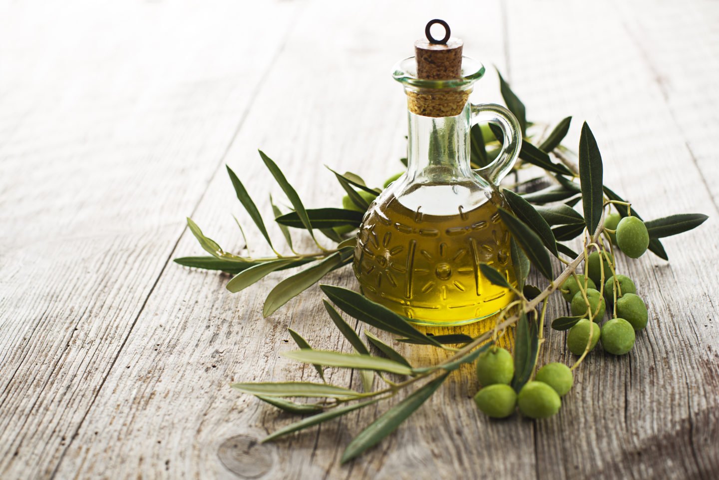 olive oil in glass bottle with olives