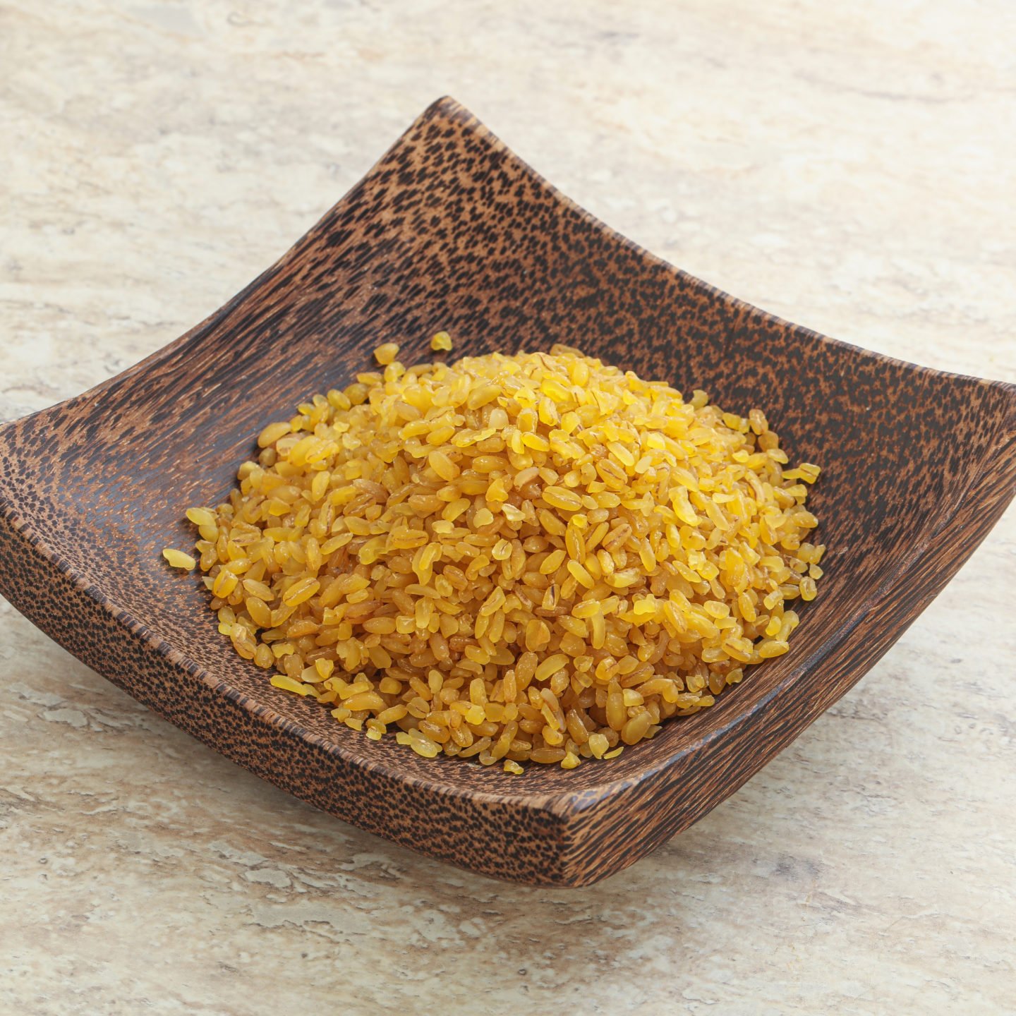 raw bulgur wheat in unique wooden bowl