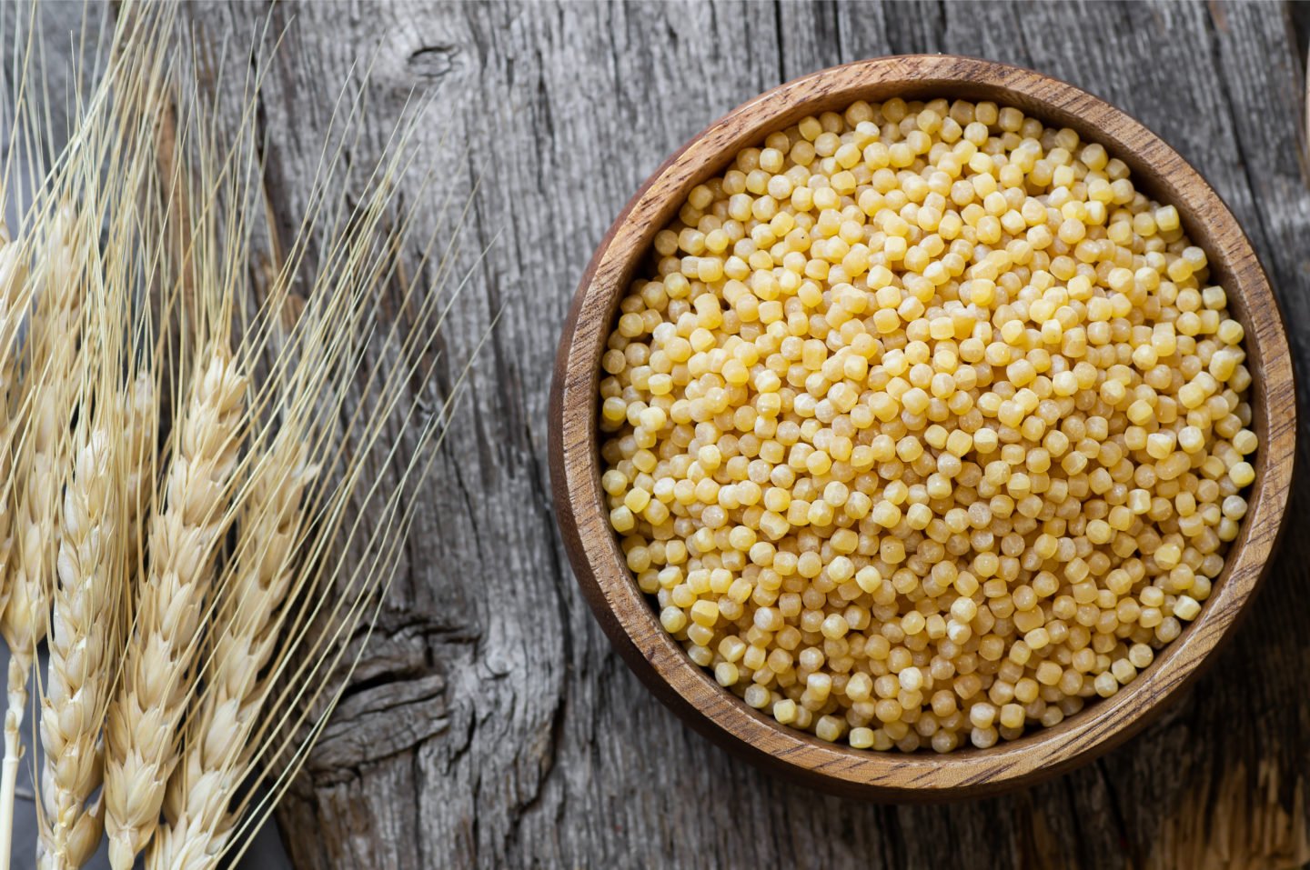 Raw Wheat Couscous In Wooden Bowl